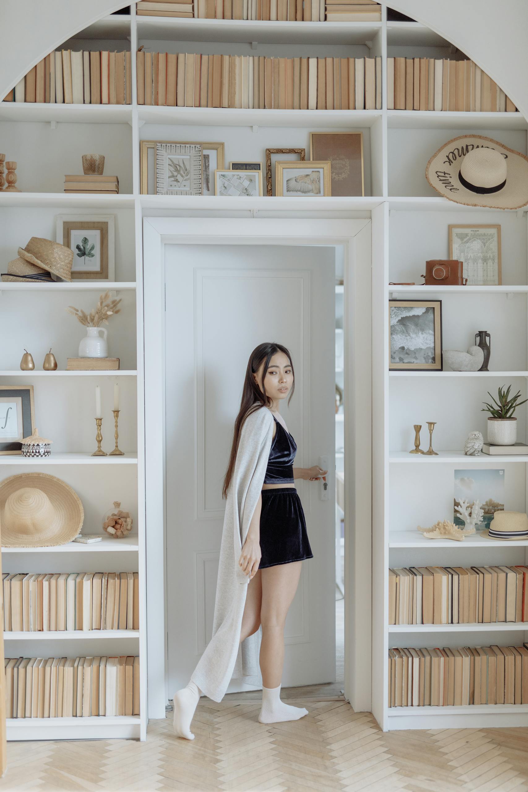 Elegant woman posing stylishly in a minimalist home interior with curated decor.